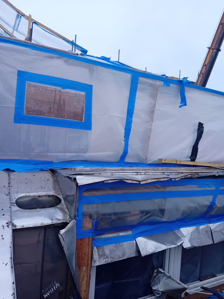 Plastic sheeting, taped using a blue tape to ensure it is air tight, with a window made of plastic